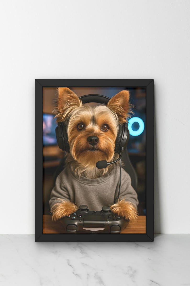 Pu&ograve; includere: Stampa incorniciata con un Yorkshire Terrier che indossa una cuffia con microfono e tiene in mano un controller per videogiochi. Il cane indossa un maglione grigio. Lo sfondo presenta una configurazione di gioco sfocata.