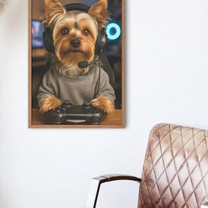 Pu&ograve; includere: Una stampa incorniciata raffigura uno Yorkshire Terrier con cuffie e un maglione grigio, che tiene in mano un controller di gioco nero. Il cane &egrave; in una configurazione di gioco con una luce al neon blu sullo sfondo. La stampa &egrave; in una cornice di legno.