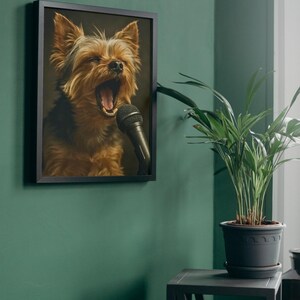 May include: Framed artwork featuring a Yorkshire Terrier with its mouth open, singing into a black microphone. The dog has brown and black fur. The artwork is in a black frame and hangs on a green wall.