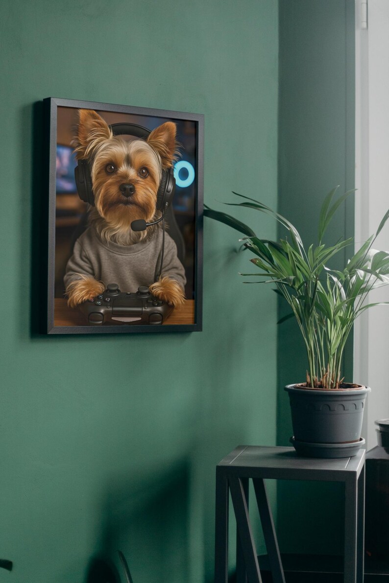 Pu&ograve; includere: Stampa incorniciata di uno Yorkshire Terrier con cuffie e un controller di videogiochi. Il cane indossa un maglione grigio. Lo sfondo mostra una configurazione di gioco con luce al neon blu.