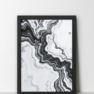 May include: Black and white abstract art print in a black frame. The artwork features a flowing, marbled design with swirling patterns. The contrast between the black and white creates a dynamic visual effect, suitable for modern home decor.