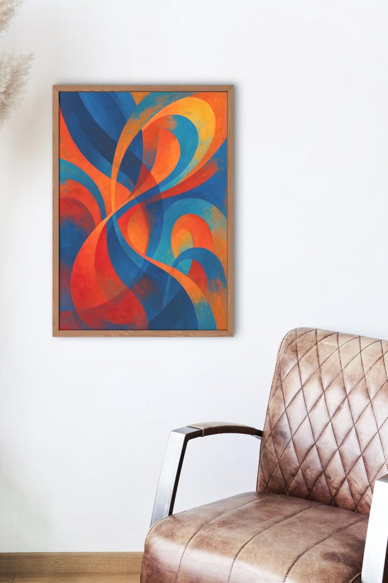 May include: Abstract art print in a wooden frame. The artwork features flowing, curved shapes in shades of blue, orange, and red. The painting is displayed on a white wall, with a brown leather chair in the foreground.