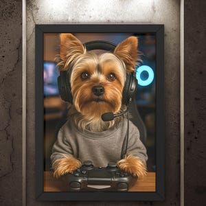 Pu&ograve; includere: Ritratto incorniciato di uno Yorkshire Terrier con cuffie e maglione grigio, che tiene in mano un controller di videogiochi nero. Il cane &egrave; al centro, su uno sfondo sfocato, in una cornice nera.