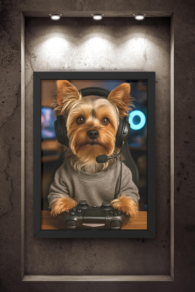 Pu&ograve; includere: Ritratto incorniciato di uno Yorkshire Terrier con cuffie e maglione grigio, che tiene in mano un controller di videogiochi nero. Il cane &egrave; al centro, su uno sfondo sfocato, in una cornice nera.