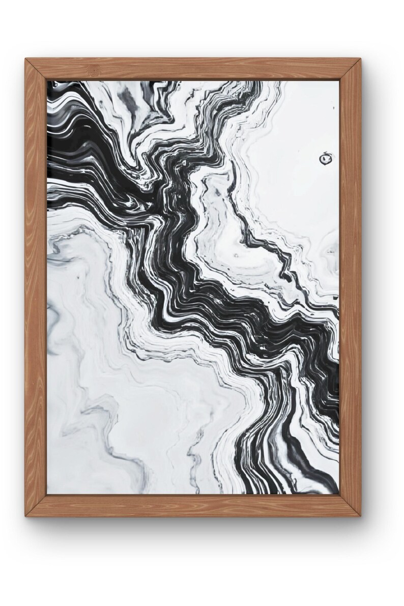 May include: Abstract art print in a wooden frame. The artwork features a black and white marbled design with flowing, wavy lines. The frame is a light brown color, providing a natural contrast to the artwork.