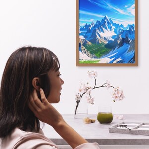 May include: A framed landscape art print depicting snow-capped mountains under a bright blue sky. A woman is seen in the foreground, with a table setting that includes a glass of green beverage, a small brush, and a vase with flowers.