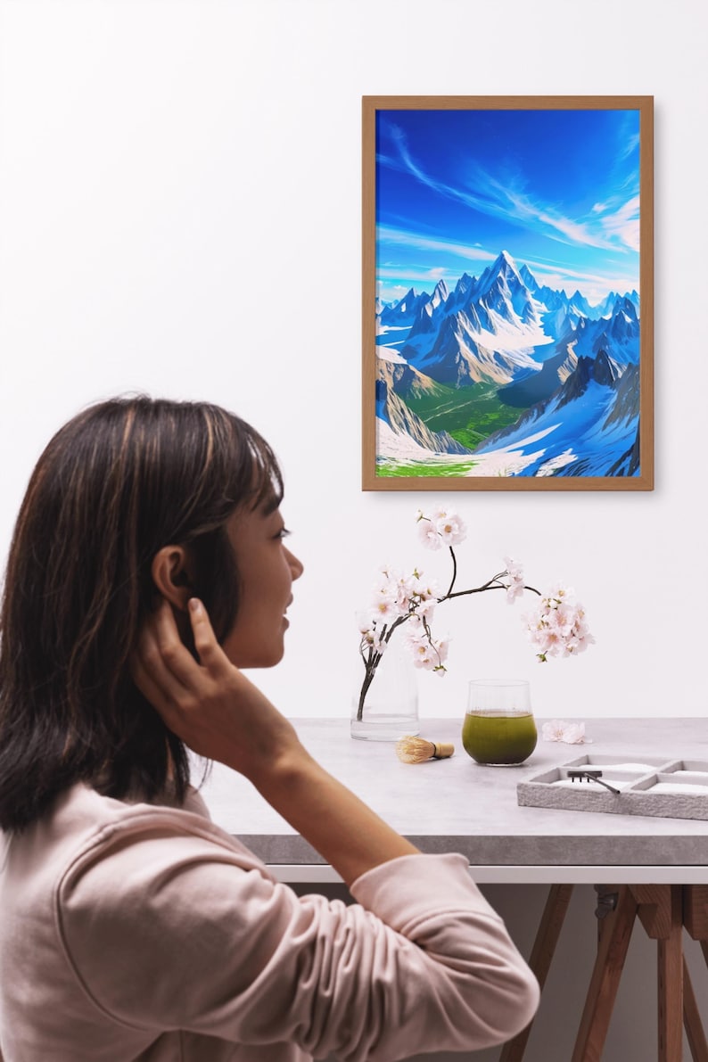 May include: A framed landscape art print depicting snow-capped mountains under a bright blue sky. A woman is seen in the foreground, with a table setting that includes a glass of green beverage, a small brush, and a vase with flowers.