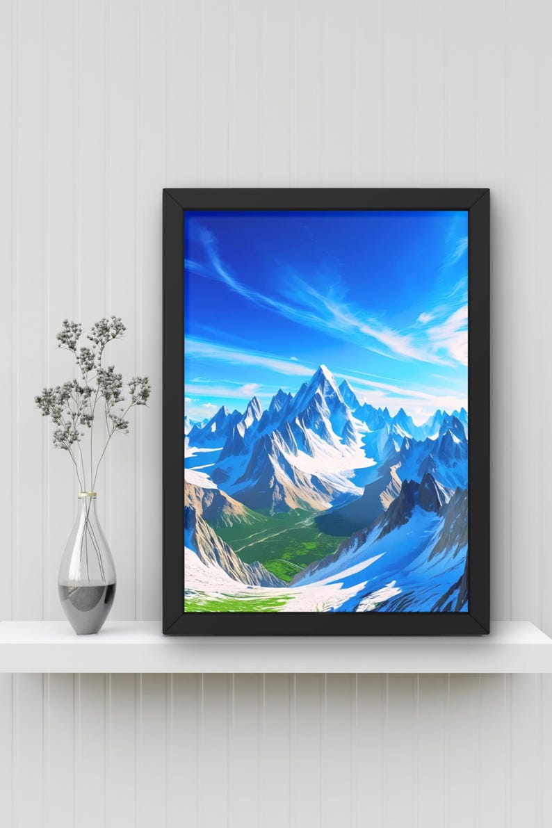 May include: A framed mountain landscape print with a black frame. The artwork depicts snow-capped mountains under a bright blue sky with wispy clouds. Green valleys are visible at the base of the mountains.
