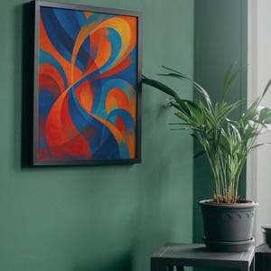 May include: Abstract art print in a black frame. The artwork features flowing, curved shapes in shades of blue, orange, and red. The framed art is mounted on a green wall. A potted plant sits on a small table next to the artwork.