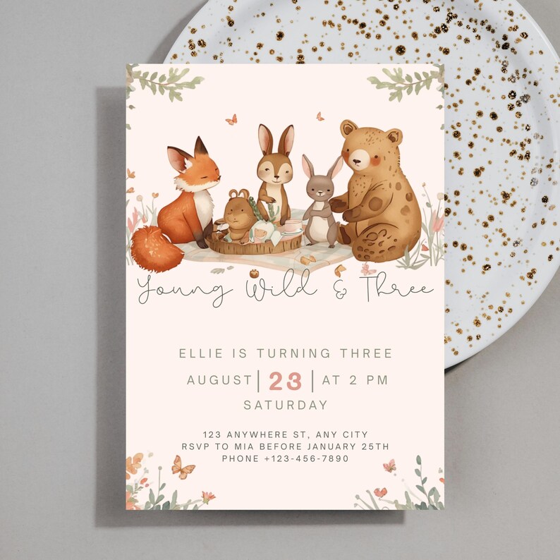 May include: A light pink birthday invitation with watercolor illustrations of woodland animals. The text reads "Young Wild & Three" and includes party details: August 23rd at 2 PM, Saturday. Includes RSVP and contact information.