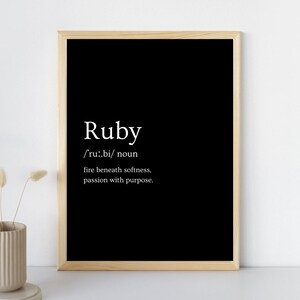 Może przedstawiać: Czarny, oprawiony wydruk z białym słowem "Ruby", wraz z wymową i definicją: "ogień pod miękkością, pasja z celem."