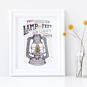 May include: A white framed print with a vintage illustration of a lantern and the text "Your word is a lamp to my feet and a light to my path Psalm 119:105".