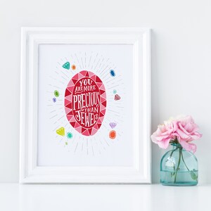 May include: White framed print with a red jewel design and the text "You are more precious than jewels". The jewel is surrounded by smaller colorful jewels.