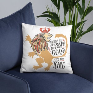 Puede incluir: Almohada blanca con un gr&aacute;fico de un le&oacute;n con una corona. El le&oacute;n est&aacute; en una pose her&aacute;ldica con la cola enroscada. El texto en la almohada dice "Claro que no es seguro, pero es bueno. Es el rey."