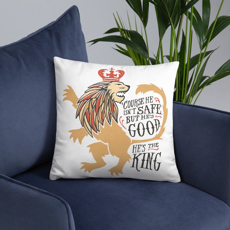 Puede incluir: Almohada blanca con un gr&aacute;fico de un le&oacute;n con una corona. El le&oacute;n est&aacute; en una pose her&aacute;ldica con la cola enroscada. El texto en la almohada dice "Claro que no es seguro, pero es bueno. Es el rey."