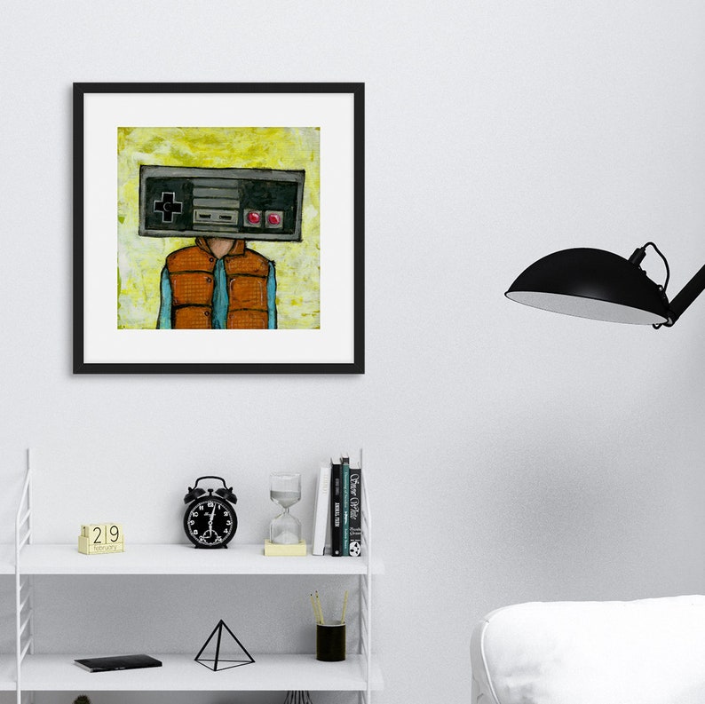 May include: A framed illustration of a person with a retro video game controller for a head. The person is wearing a blue shirt and an orange vest. The background is yellow with a watercolor effect.