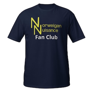 May include: Navy blue t-shirt with the text "Norwegian Nuisance Fan Club" in yellow and white. The design features two stylized yellow "N" letters. The shirt is a short-sleeved crew neck.
