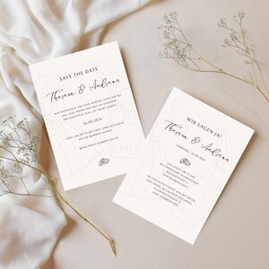 May include: Two cream-colored wedding invitation cards with elegant script text. The cards feature the names "Theresa & Andreas" and the date "26.08.2026". Delicate line drawings of wedding attire and rings adorn the design.