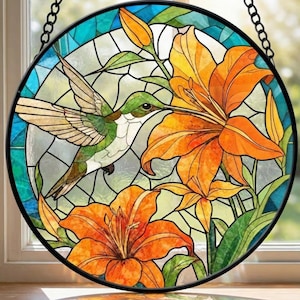 May include: A round stained glass window featuring a hummingbird and orange lilies. The hummingbird is green and white with outstretched wings, hovering near the flowers. The lilies are a vibrant orange, set against a background of blue and clear glass.