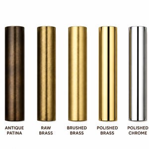 May include: Seven cylindrical metal tubes arranged in a row, featuring distinct finishes labeled as black brass, antique patina, raw brass, brushed brass, polished brass, polished chrome, and brushed chrome, each with a smooth, vertical orientation.