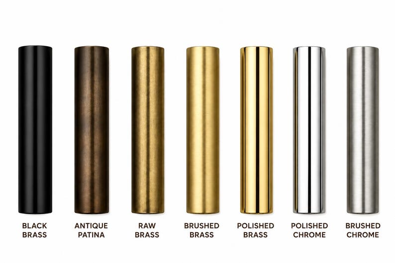 May include: Seven cylindrical metal tubes arranged in a row, featuring distinct finishes labeled as black brass, antique patina, raw brass, brushed brass, polished brass, polished chrome, and brushed chrome, each with a smooth, vertical orientation.