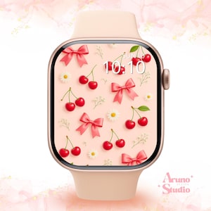 Puede incluir: Un reloj inteligente de color rosa claro con una pantalla digital que presenta un patrón repetitivo de cerezas rojas, lazos rosas y margaritas blancas. La pantalla muestra la hora 10:10 y la fecha SUN 10. El reloj tiene un acabado mate y corona.