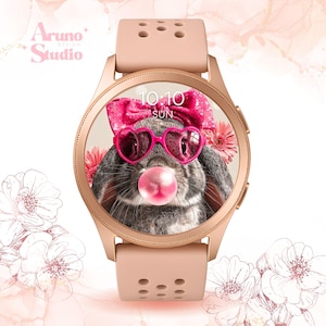 Puede incluir: Un reloj inteligente de oro rosa con una correa rosa. La esfera del reloj muestra un conejo gris con gafas de sol rosas en forma de corazón y un lazo rosa, soplando una burbuja de chicle. La hora es 10:10, domingo. La marca "Aruno Studio" es visible.