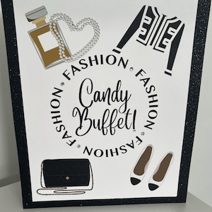 May include: A white card with black glitter trim features a black and white illustration of a Chanel-inspired outfit, a purse, shoes, and perfume bottle. The text "Fashion Candy Buffet! Fashion" is written in a circle around the center of the card.