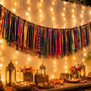 May include: A decorative garland featuring numerous hanging fabric strips in a vibrant array of colors and patterns, including red, blue, purple, and gold. The strips are tied to a horizontal cord, creating a dense, textured, and festive display.