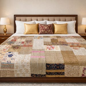 Könnte beinhalten: Ein Bett mit einer Patchwork-Steppdecke mit verschiedenen Mustern und Farben, darunter Beige, Braun und florale Designs. Das Bett hat einen Holzrahmen, ein gepolstertes Kopfteil und ist mit goldenen und gemusterten Kissen geschmückt. Zwei Lampen stehen auf den Nachttischen.
