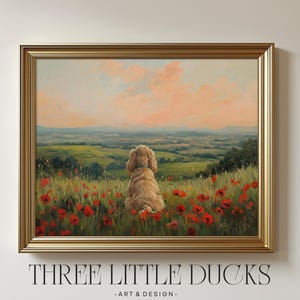 Puede incluir: Pintura enmarcada que representa un perro dorado sentado en un campo de amapolas rojas, con vistas a un valle verde bajo un cielo de atardecer. La obra de arte está en un marco dorado, con el texto "THREE LITTLE DUCKS - ART & DESIGN" en la parte inferior.