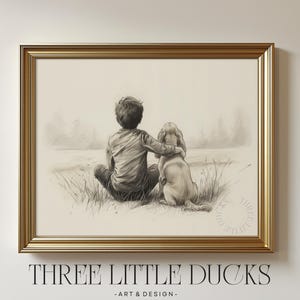 Könnte beinhalten: Ein gerahmter Bleistiftskizzen-Druck mit einem Kind und einem Hund, die zusammen in einem Feld sitzen. Das Kunstwerk befindet sich in einem goldenen Rahmen und trägt unten den Text "THREE LITTLE DUCKS - ART & DESIGN".
