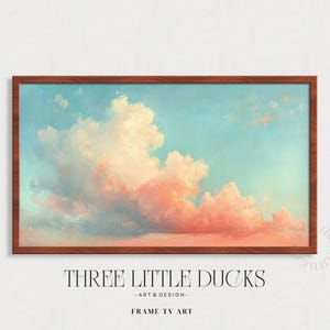 Può includere: Una stampa artistica incorniciata con un cielo pastello con nuvole rosa e bianche su uno sfondo azzurro. L'opera d'arte è in una cornice di legno marrone. Il testo "THREE LITTLE DUCKS - ART & DESIGN - FRAME TV ART" è in basso.