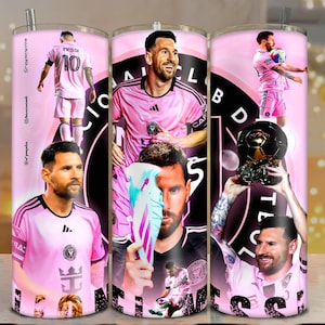 May include: A set of three stainless steel tumblers featuring a pink and black design with images of a soccer player. The tumblers have a silver straw and a pink background with the team's logo and player images.