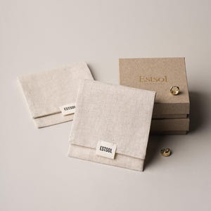 May include: A set of three ceramic mugs with a speckled, matte finish. The mugs are in shades of cream, light gray, and dark gray. Each mug has a simple, minimalist design, perfect for coffee or tea.