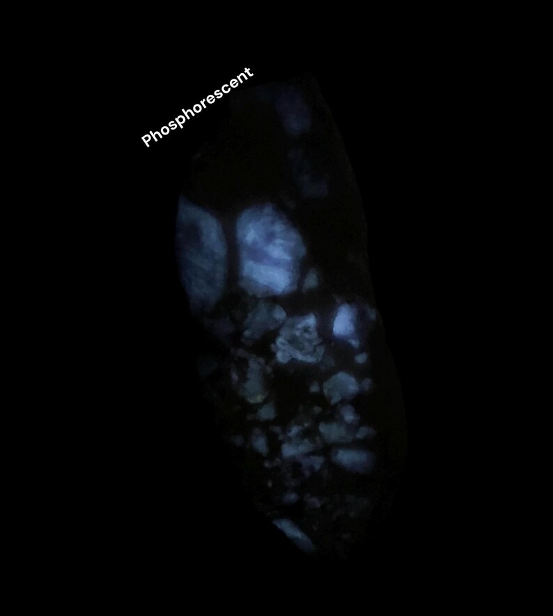 May include: A dark image of a rock with a glowing, blue, phosphorescent effect. The word "Phosphorescent" is written in white at the top left of the image. The rock has a rough texture.