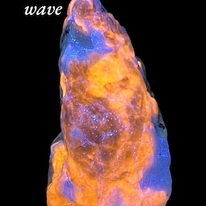 May include: A glowing rock formation with a rough texture, displaying vibrant orange and blue hues against a black background. The text "Long wave" is written in white in the upper left corner.
