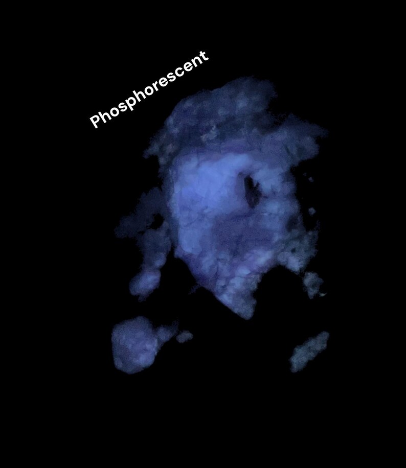 May include: A dark image featuring a blue, cloud-like shape with the word "Phosphorescent" in white text. The blue shape has a textured appearance against a black background.