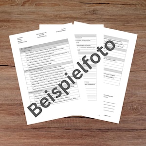 May include: Three white sheets of paper with German text, including the word "Beispielfoto" in large, dark gray letters, are arranged on a brown wooden surface. The papers contain lists and forms, suggesting a document or paperwork theme.