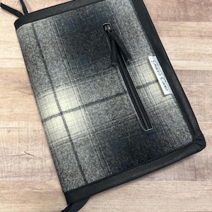 May include: Black and white plaid zippered clutch with a black leather trim and the text "Grace's Cakes" on the front.