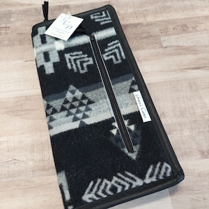 May include: Black and white geometric patterned fabric zippered pouch with a black leather trim and a white label that reads "Grace'd Cases".