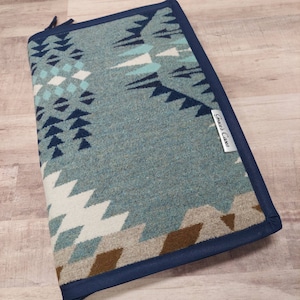 May include: A blue and white patterned laptop sleeve with a navy blue border and a "Great Cases" label.