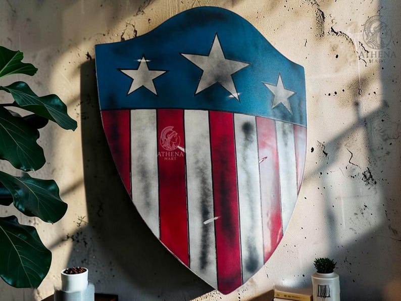 May include: A shield with a blue top section featuring three white stars and a red and white striped bottom. The shield is mounted on a textured wall. The shield has a distressed, vintage appearance.