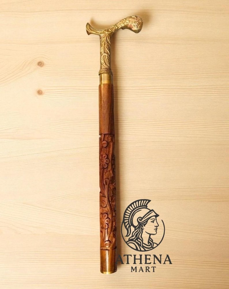 May include: A decorative walking cane with a brass handle and accents. The handle is curved and features intricate floral detailing. The wooden shaft is carved with floral patterns. The cane is approximately 36 inches long.