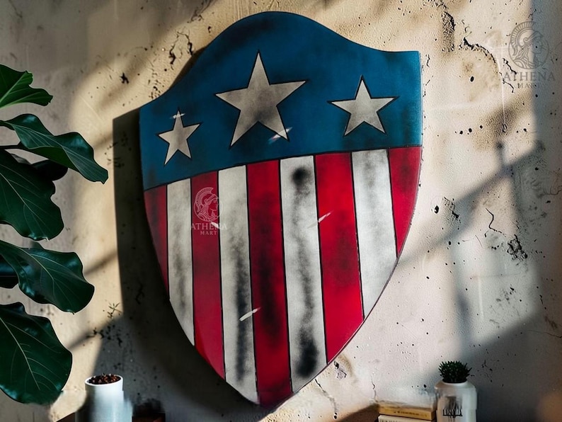 May include: A shield with a blue top section featuring three white stars and a red and white striped lower section. The shield is mounted on a textured wall. The shield has a distressed, vintage appearance.