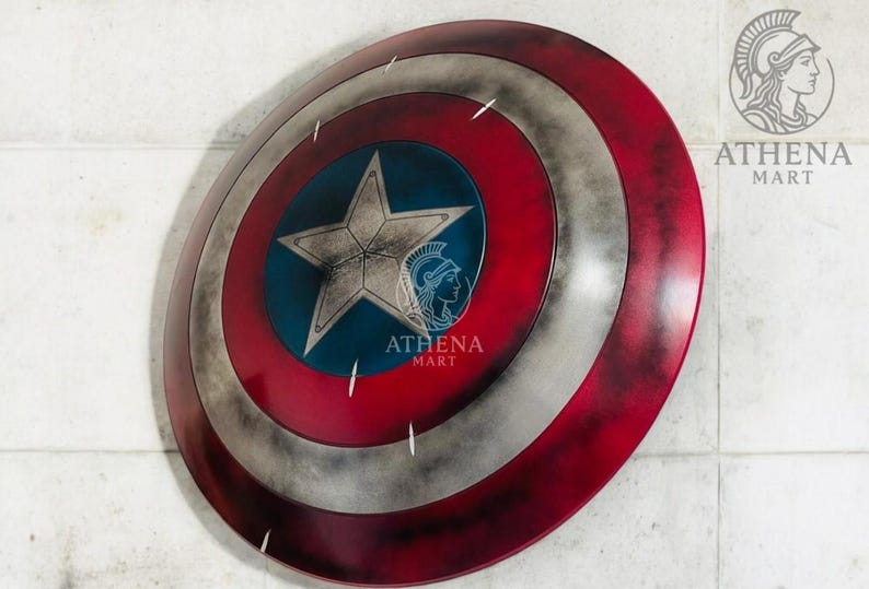 May include: A Captain America shield, featuring a red, white, and blue color scheme with a central blue star. The shield has a distressed, weathered appearance, with a silver star in the center. The shield is a replica of the iconic superhero prop.
