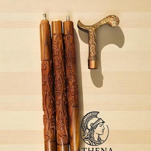 May include: A wooden walking cane with a decorative brass handle and three carved wooden sections. The handle features an ornate floral design. The cane sections are brown with carved floral patterns. The logo for Athena Mart is visible.
