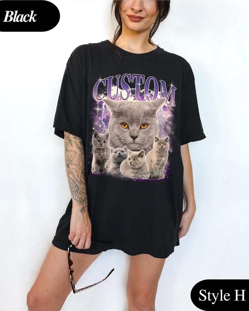 Puede incluir: Camiseta negra con un gr&aacute;fico de un gato gris y gatitos, con la palabra "CUSTOM" arriba. El dise&ntilde;o incluye un rayo p&uacute;rpura y estrellas. La camiseta est&aacute; etiquetada como "Style H".