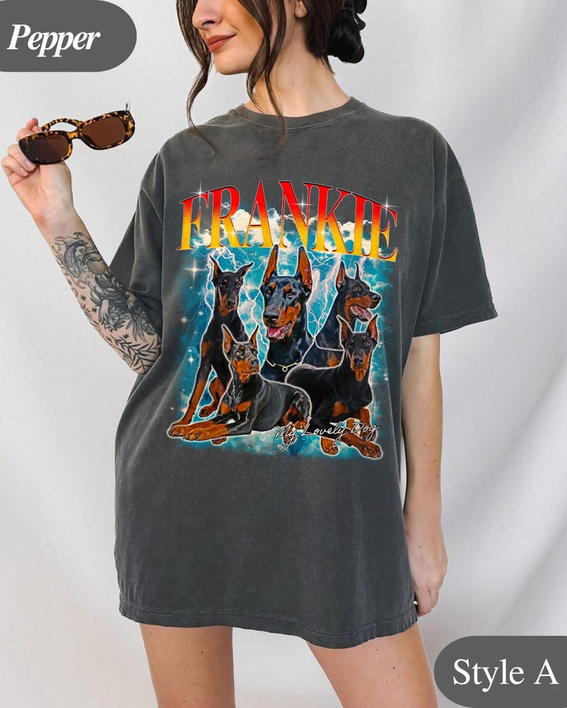 Puede incluir: Camiseta gris oscuro con un gr&aacute;fico de cinco Doberman Pinschers y el nombre "FRANKIE" en una fuente retro. El dise&ntilde;o incluye rayos y la frase "My lovely dogs".
