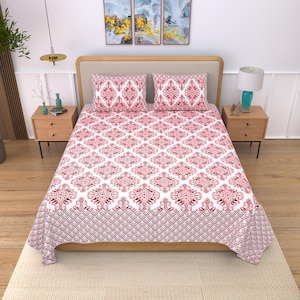 May include: A bed set featuring a white and red patterned design. The set includes a fitted sheet, a flat sheet, and two pillowcases. The pattern is a repeating geometric design with a decorative border.
